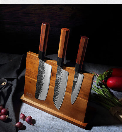 The Frontier Solid Wood Magnetic Knife Holder showcased from above in a dark kitchen with shallots and asparagus in the background