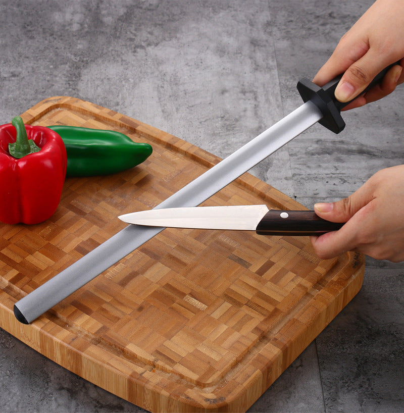 TrailMaster 12" Emery Knife Honing Rod being shown over a cutting board with peppers to the left and a utility knife to the right