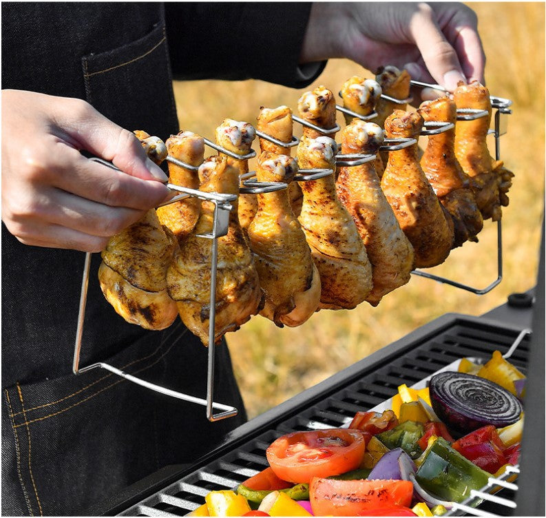 Trailblazer BBQ Rack 14-Slot Stainless Steel Masterpiece shown above a grill with cooked chicken drumstick hanging from the slots