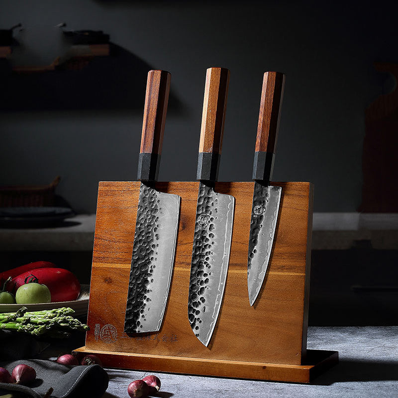 The Frontier Solid Wood Magnetic Knife Holder with three knives showcased in a dark kitchen