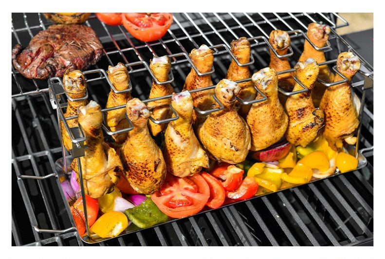 Trailblazer BBQ Rack 14-Slot Stainless Steel Masterpiece drumsticks cooking on the grill above assorted colorful vegetables